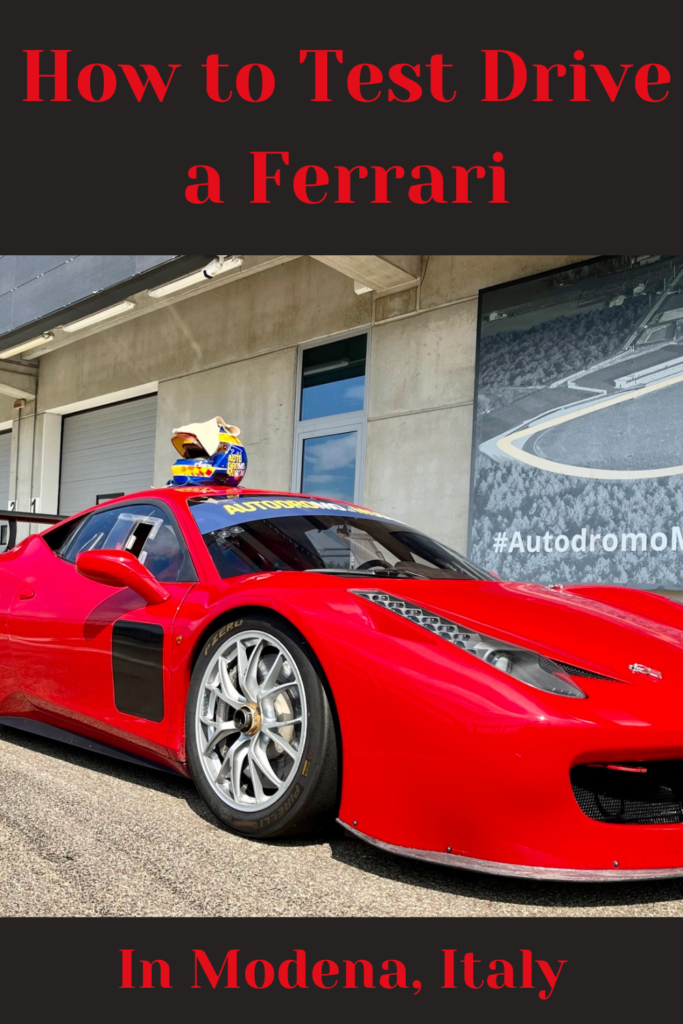 a red car with a helmet on top sitting on a race track