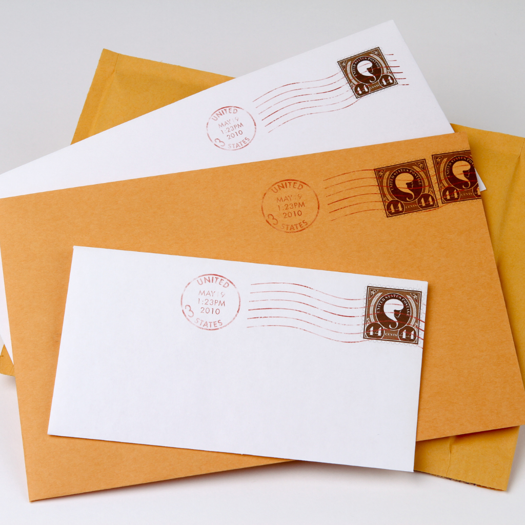 white and brown envelopes with stamps